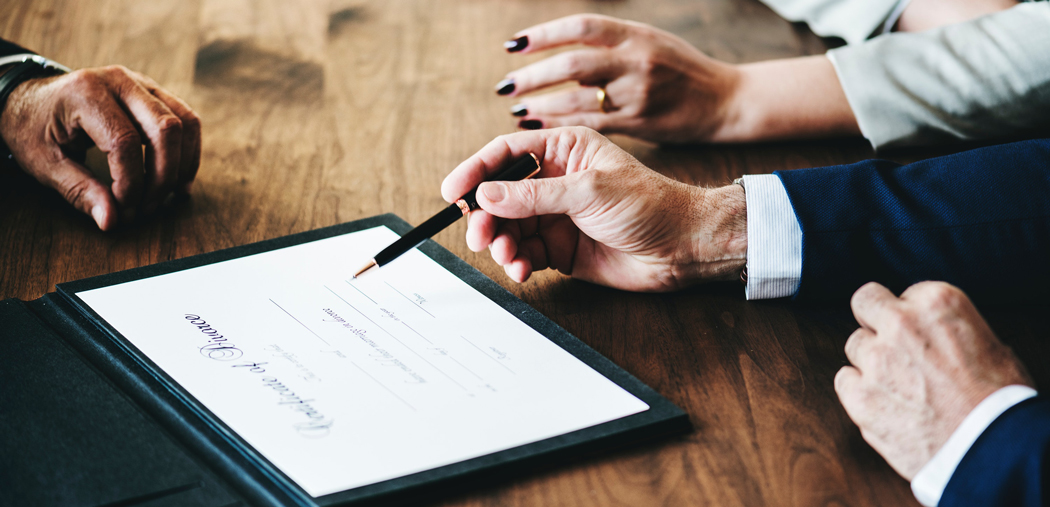 couple signing divorce document with pen