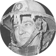 Black and white image of a firefighter wearing a helmet and the water on helmet is frozen