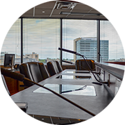 brown desk with microphones and chairs with the skyline in the back