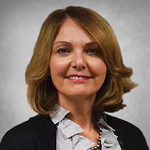 board member headshot wearing black suite with a blue collared shirt blonde hair