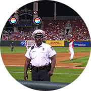 police office in uniform standing guard on a baseball field during a baseball game