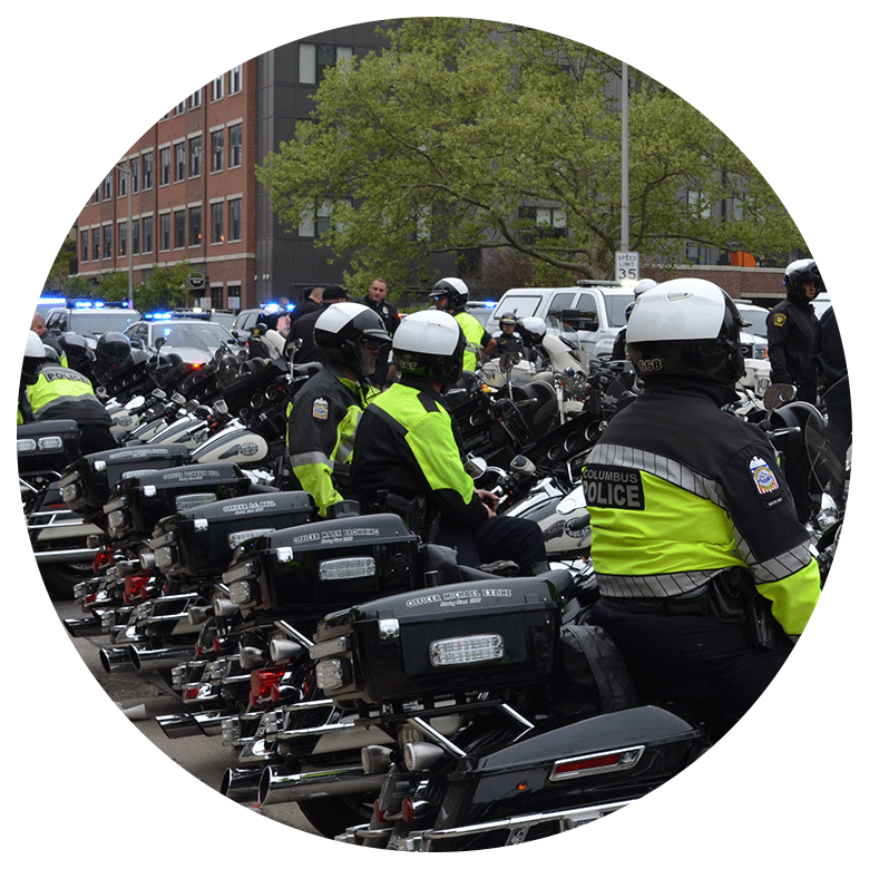 small group of uniformed police officers sitting on black motorcycles outside